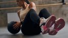 woman doing medicine ball twist, concept of ab workouts that burn the most calories