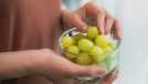 woman holding grapes, concept of can eating grapes help you lose weight